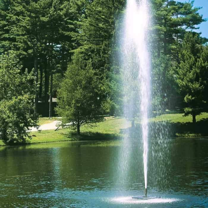 Beautiful sight of the Scott Aerator Gusher Floating Pond Fountain 1 1/2 Hp Floating Fountain as a large pond fountain or small lake fountain.  The brilliant white spray going up and falling back down into the lake that is reflecting purple and blue colors as well as the forest park background.  A fantastic view of the floating water fountain.